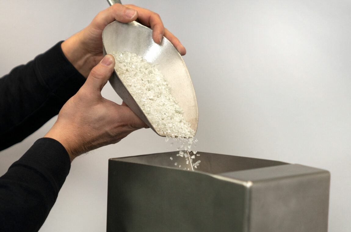 Two-roller mill Material feed - glass splinters are poured into the feed hopper for crushing.